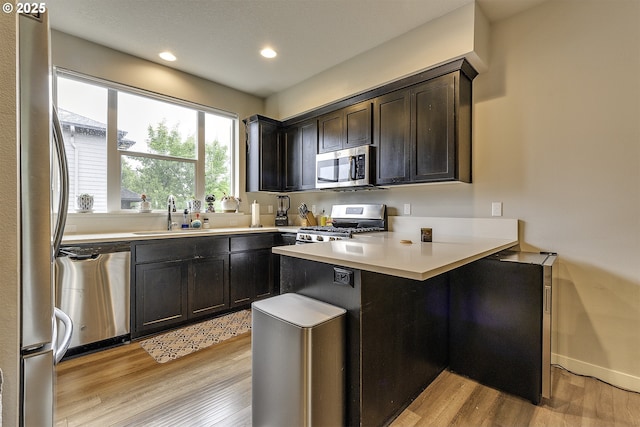 475 NE Liberty Ave, Gresham, OR 97030 - kitchen featuring appliances with stainless steel finishes, a peninsula, light wood-style flooring, light countertops, and recessed lighting