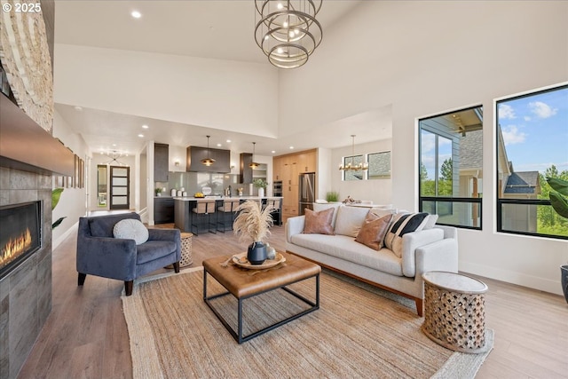 750 N V St, Washougal, WA 98671 - living room featuring a chandelier, light wood finished floors, a towering ceiling, a fireplace, and recessed lighting