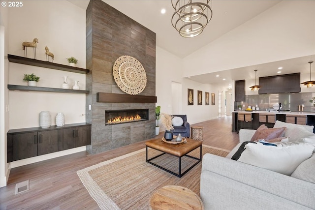 750 N V St, Washougal, WA 98671 - living area with wood finished floors, high vaulted ceiling, a tile fireplace, baseboards, and recessed lighting