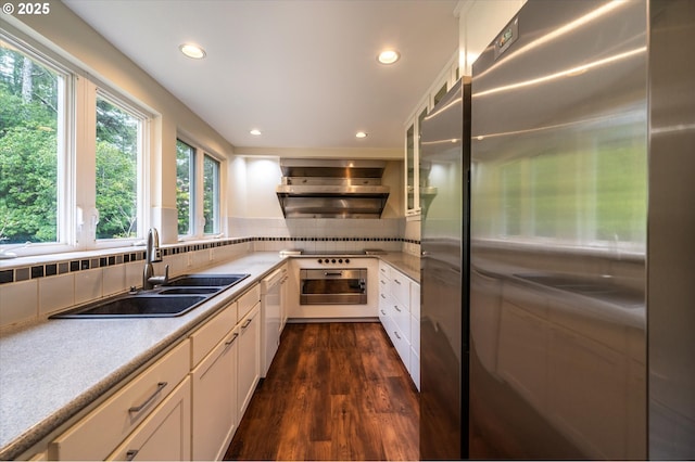 88771 Tokyo Ln, Bandon, OR 97411 - kitchen with freestanding refrigerator, wall chimney exhaust hood, dark wood-style flooring, recessed lighting, and white cabinets