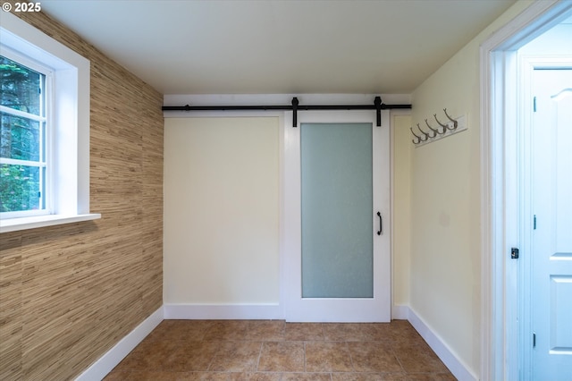 88771 Tokyo Ln, Bandon, OR 97411 - tiled empty room featuring a barn door and baseboards