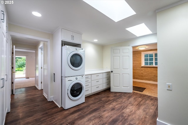 88771 Tokyo Ln, Bandon, OR 97411 - laundry room featuring stacked washing machine and dryer, a skylight, dark wood finished floors, cabinet space, and ornamental molding