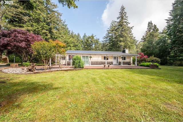 88771 Tokyo Ln, Bandon, OR 97411 - rear view of property with a chimney, a lawn, a metal roof, stone siding, and a standing seam roof