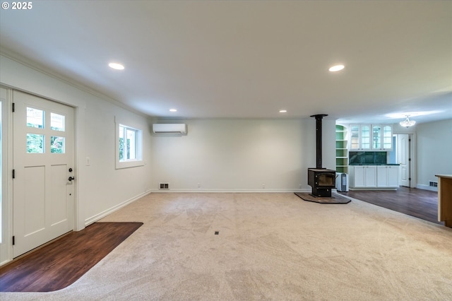 88771 Tokyo Ln, Bandon, OR 97411 - below grade area with a wall mounted AC, carpet flooring, a wood stove, recessed lighting, and crown molding