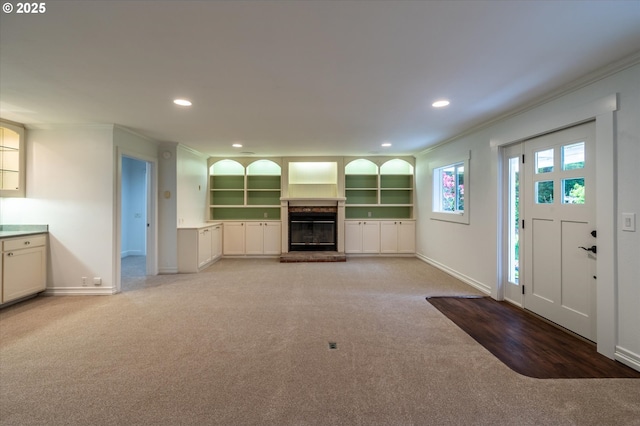88771 Tokyo Ln, Bandon, OR 97411 - unfurnished living room featuring light carpet, ornamental molding, recessed lighting, and a brick fireplace