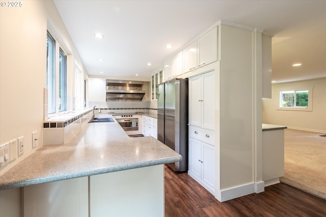 88771 Tokyo Ln, Bandon, OR 97411 - kitchen featuring appliances with stainless steel finishes, wall chimney range hood, tasteful backsplash, white cabinets, and recessed lighting