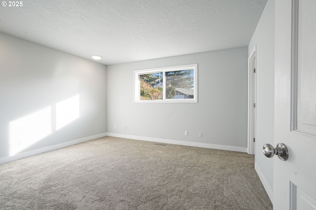 empty room featuring a textured ceiling and carpet floors