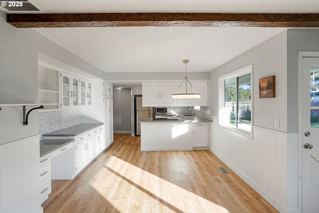 kitchen featuring stainless steel appliances, white cabinets, and decorative light fixtures