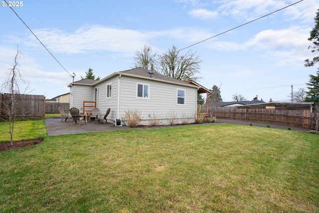 rear view of house featuring a yard, a fenced backyard, and a patio area