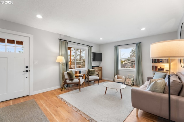 living room with light wood-style flooring, plenty of natural light, recessed lighting, and baseboards