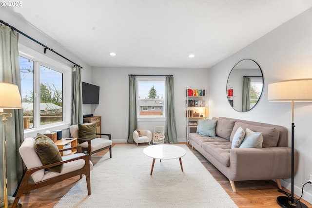 living room with recessed lighting, baseboards, and light wood-style floors