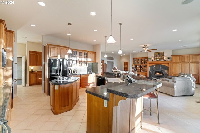 6904 SW Joshua Ct, Powell Butte, OR 97753 - kitchen featuring an island with sink, refrigerator with ice dispenser, recessed lighting, black dishwasher, and a kitchen breakfast bar
