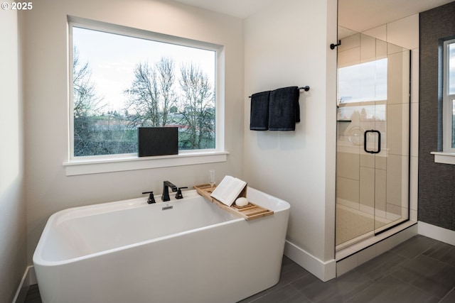 full bath with a freestanding bath, a shower stall, and baseboards