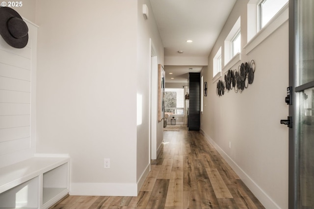 corridor with recessed lighting, wood finished floors, and baseboards