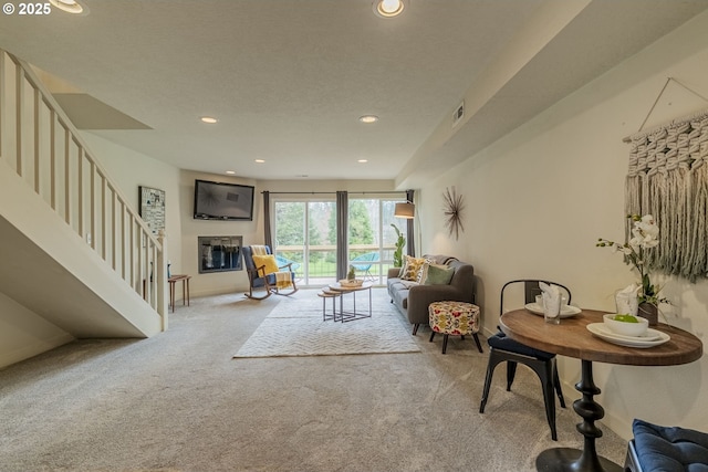 living room featuring visible vents, baseboards, stairway, carpet flooring, and recessed lighting