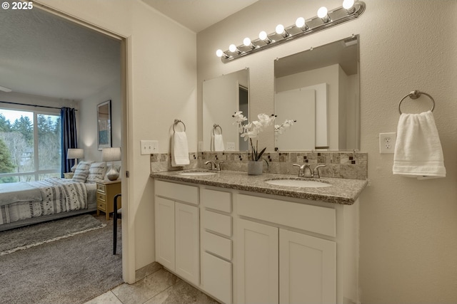 ensuite bathroom with tile patterned flooring, double vanity, ensuite bathroom, and a sink