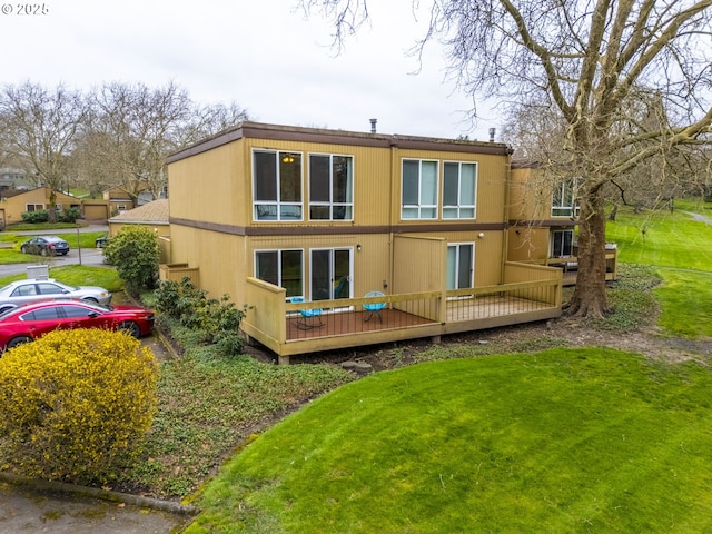 rear view of property featuring a wooden deck and a yard