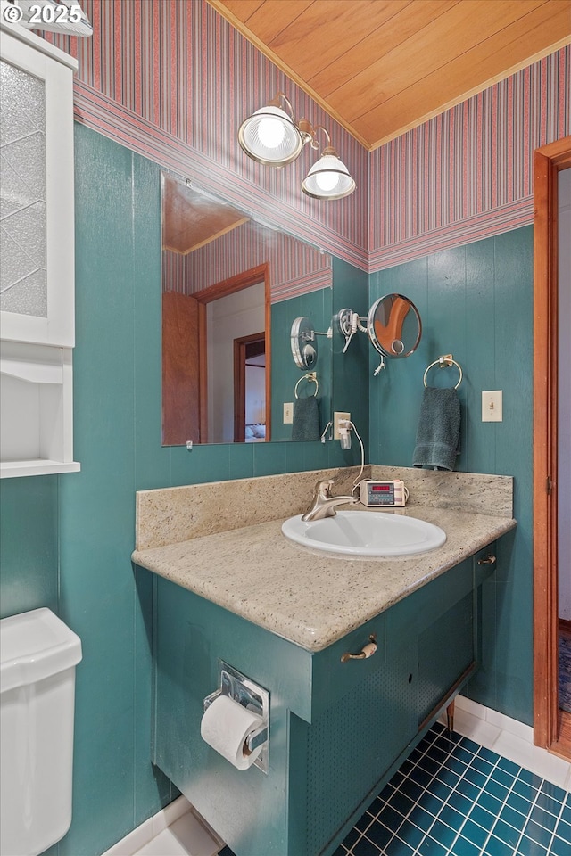 320 El Rotundo Ave, Lincoln City, OR 97367 - half bathroom featuring vanity, tile patterned flooring, toilet, wallpapered walls, and baseboards