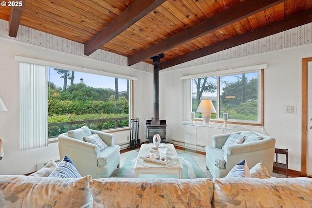320 El Rotundo Ave, Lincoln City, OR 97367 - living room with a wood stove, plenty of natural light, wooden ceiling with exposed beams, baseboards, and wood finished floors