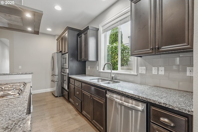 7698 NW Catalpa St, Portland, OR 97229 - kitchen featuring appliances with stainless steel finishes, a sink, wall chimney exhaust hood, recessed lighting, and light wood-style flooring