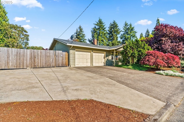 garage with fence and concrete driveway