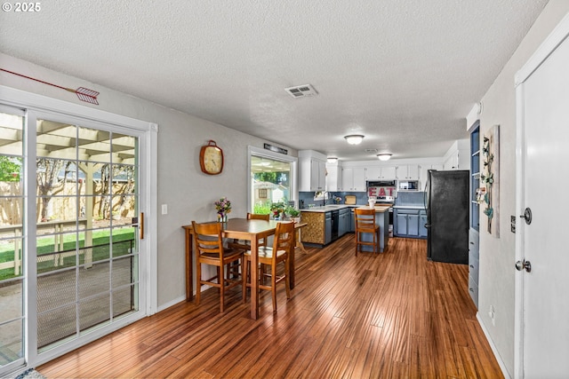 3131 Alyndale Dr, Eugene, OR 97404 - kitchen with black appliances, dark wood-style floors, a textured ceiling, light countertops, and white cabinets
