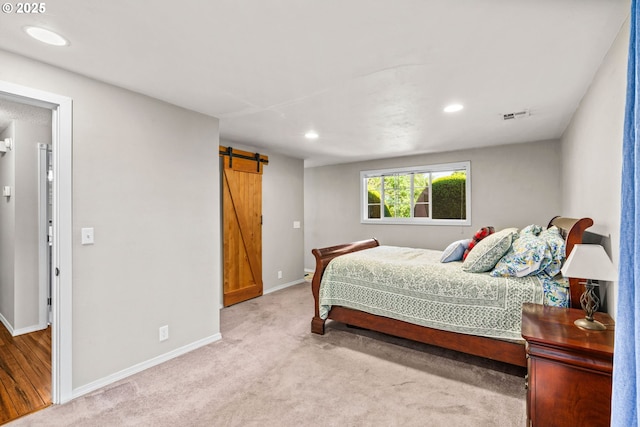 bedroom featuring a barn door, baseboards, recessed lighting, and carpet