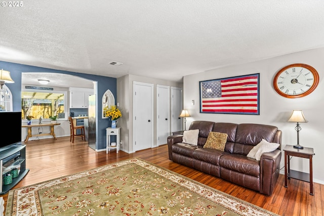 3131 Alyndale Dr, Eugene, OR 97404 - living room with hardwood / wood-style flooring, a textured ceiling, baseboards, and arched walkways