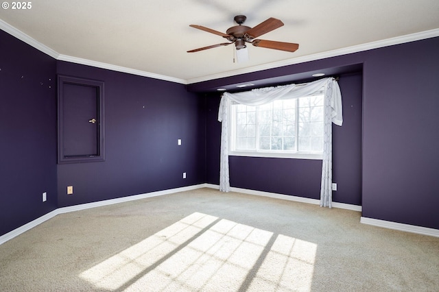 carpeted empty room with ornamental molding, ceiling fan, and baseboards