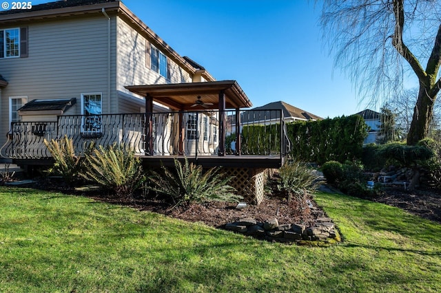 back of property featuring a deck and a lawn