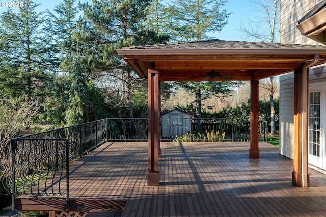 deck with a shed, ceiling fan, and an outdoor structure