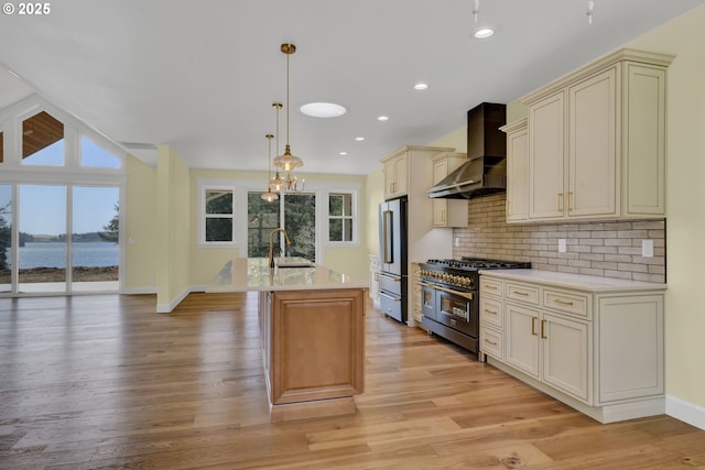 83594 Sauter Dr, Florence, OR 97439 - kitchen with high quality appliances, wall chimney range hood, cream cabinetry, light countertops, and a sink
