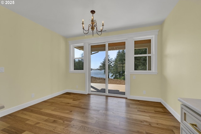 83594 Sauter Dr, Florence, OR 97439 - unfurnished dining area featuring a chandelier, baseboards, and wood finished floors