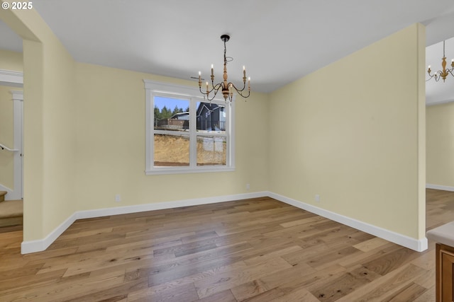 83594 Sauter Dr, Florence, OR 97439 - unfurnished dining area with a chandelier, wood finished floors, stairway, and baseboards