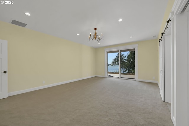 83594 Sauter Dr, Florence, OR 97439 - spare room with light carpet, a barn door, a chandelier, baseboards, and recessed lighting