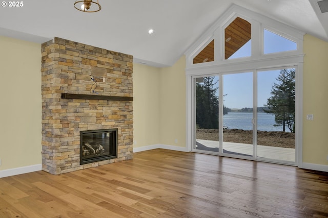 83594 Sauter Dr, Florence, OR 97439 - unfurnished living room featuring lofted ceiling, a fireplace, wood finished floors, and baseboards