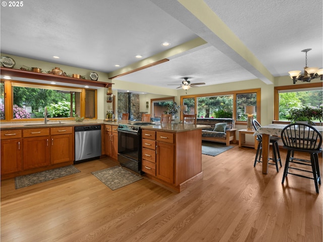 24880 E Arrah Wanna Blvd, Welches, OR 97067 - kitchen with dishwasher, a sink, black electric range, brown cabinets, and a peninsula