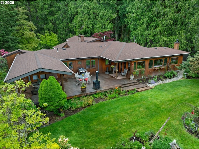 24880 E Arrah Wanna Blvd, Welches, OR 97067 - back of house featuring a chimney, a lawn, a deck, a shingled roof, and a view of trees