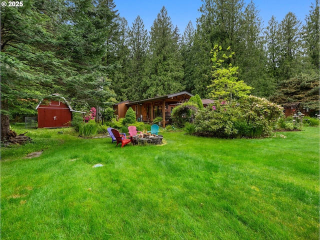 24880 E Arrah Wanna Blvd, Welches, OR 97067 - view of green lawn featuring a fire pit, an outdoor structure, and a view of trees