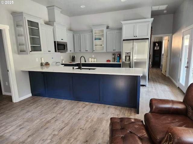 78115 Giger Ln, Weston, OR 97886 - kitchen featuring a sink, stainless steel appliances, a peninsula, open floor plan, and light wood-type flooring