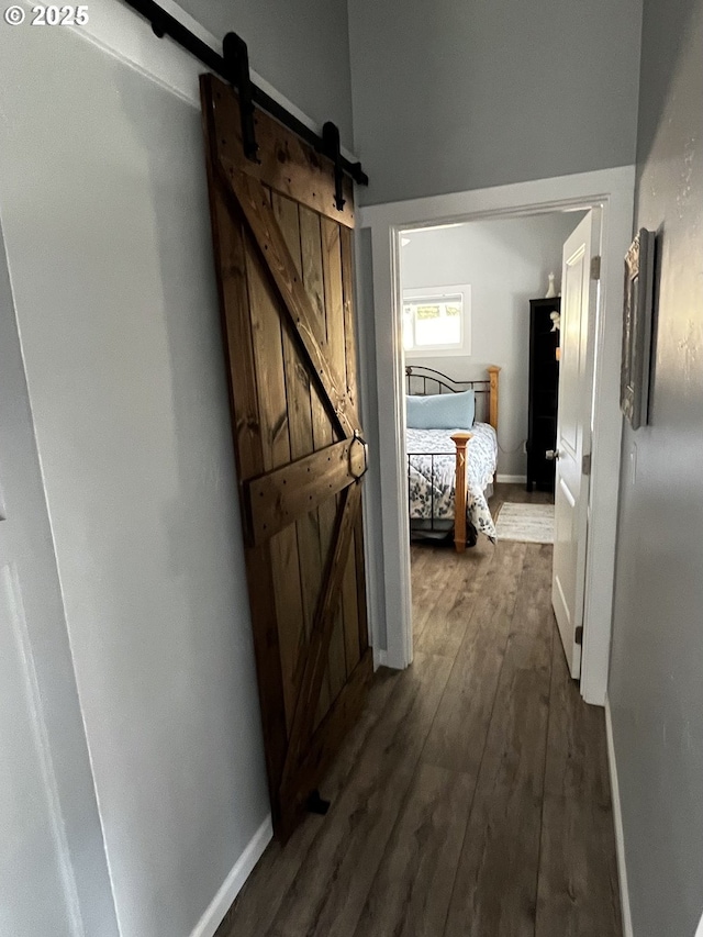78115 Giger Ln, Weston, OR 97886 - corridor featuring a barn door, dark wood-style flooring, and baseboards