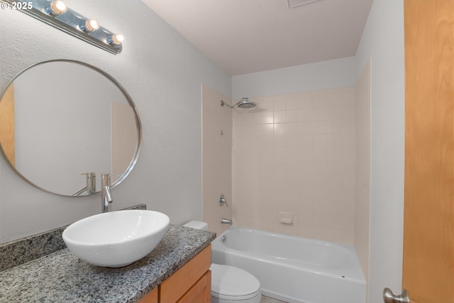 full bathroom featuring tiled shower / bath combo, vanity, and toilet