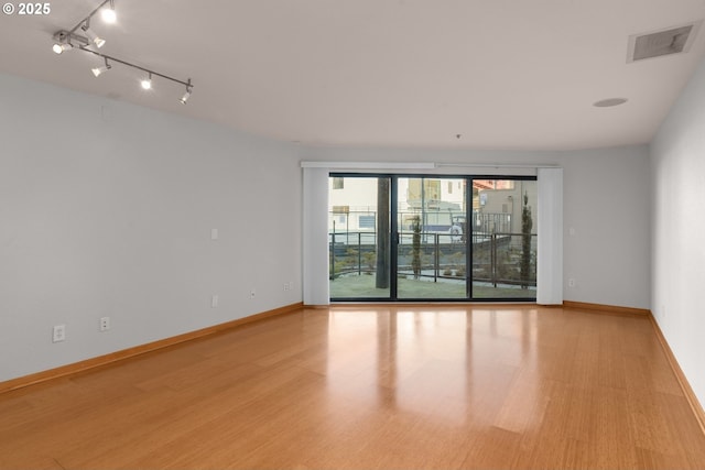 unfurnished room with rail lighting and light wood-type flooring