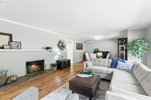 819 SE 98th Ave, Vancouver, WA 98664 - living room featuring a wall unit AC, wood finished floors, a fireplace, a textured ceiling, and crown molding