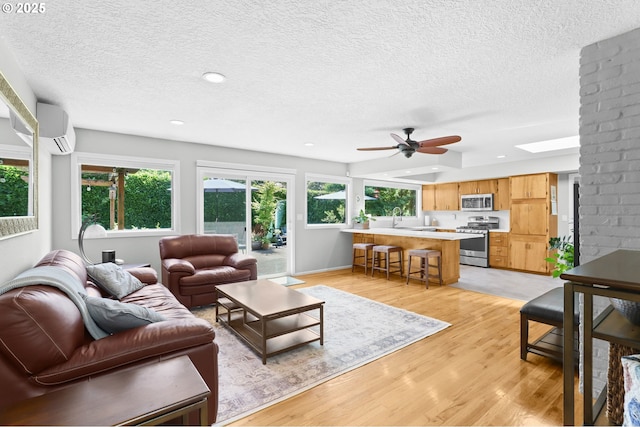 819 SE 98th Ave, Vancouver, WA 98664 - living room with a wall mounted air conditioner, a ceiling fan, light wood-type flooring, a textured ceiling, and recessed lighting