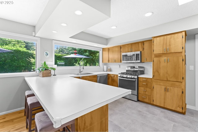 819 SE 98th Ave, Vancouver, WA 98664 - kitchen featuring stainless steel appliances, light countertops, a peninsula, healthy amount of natural light, and recessed lighting