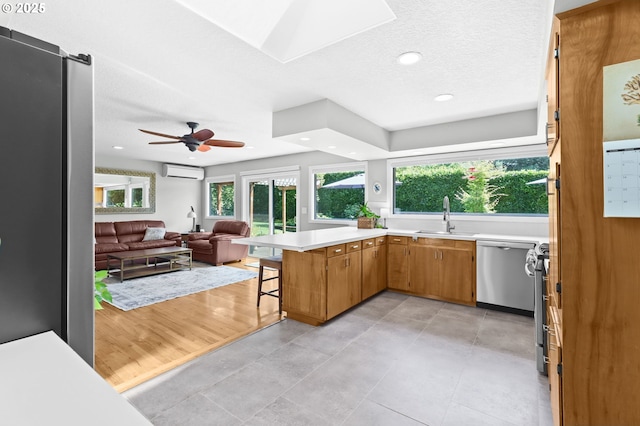 819 SE 98th Ave, Vancouver, WA 98664 - kitchen with a wall unit AC, dishwasher, light countertops, open floor plan, and a kitchen breakfast bar
