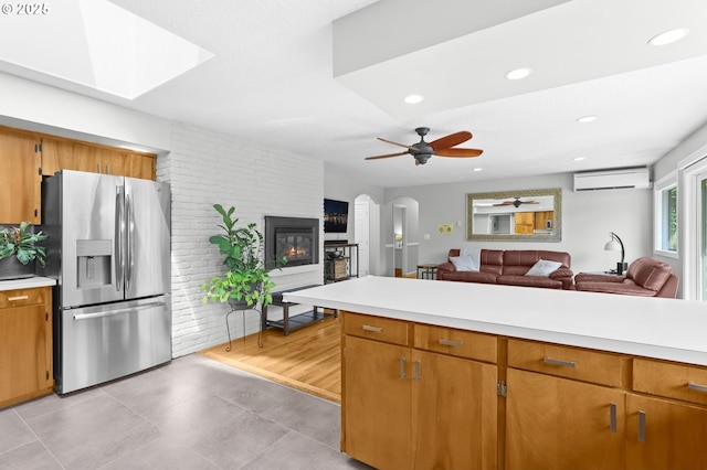 819 SE 98th Ave, Vancouver, WA 98664 - kitchen with stainless steel fridge, a wall unit AC, open floor plan, light countertops, and a fireplace