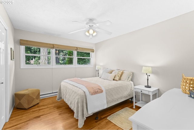 819 SE 98th Ave, Vancouver, WA 98664 - bedroom with a baseboard heating unit, multiple windows, wood finished floors, and a ceiling fan