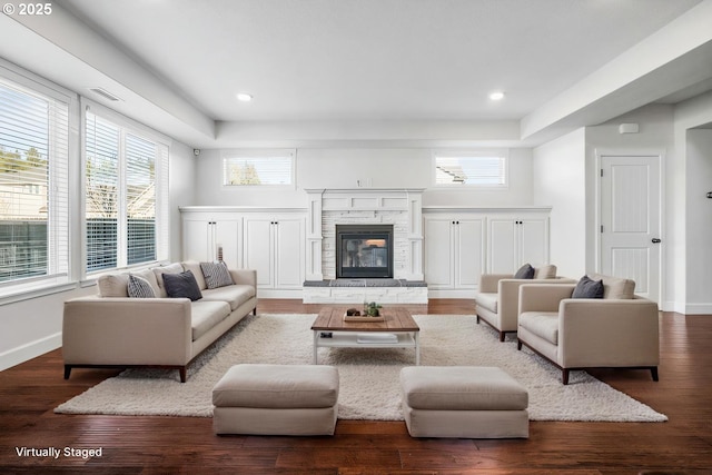 living area featuring visible vents, baseboards, and wood finished floors